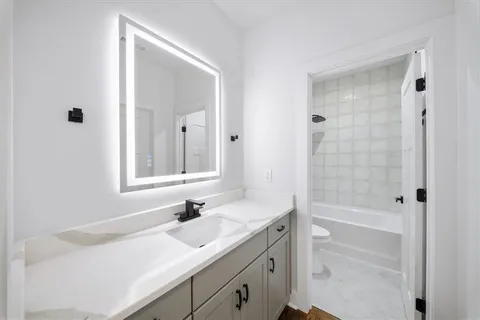 a spacious bedroom with a bed and wooden floor