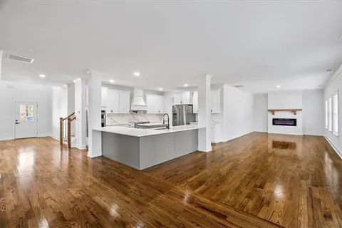 a view of a living room a fireplace wooden floor and a window