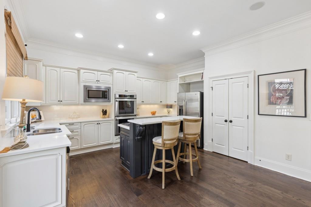 3585 Roxboro Road Northeast, Unit 6 Atlanta, GA 30326 - Photo 23 of 51 a kitchen with a table chairs refrigerator and cabinets