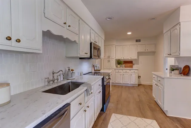 a kitchen with a sink a stove and cabinets