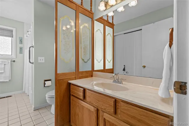 a bathroom with a granite countertop sink a toilet and shower
