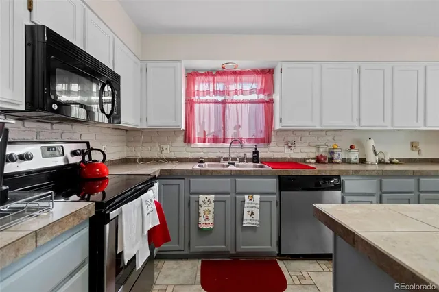 a kitchen with stainless steel appliances granite countertop a stove sink and cabinets
