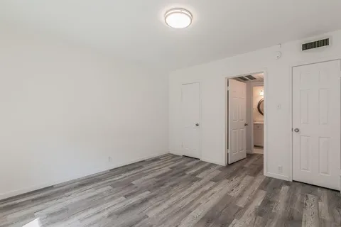 a view of a room with wooden floor and white walls