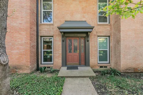 a front view of a house with a yard and potted plants