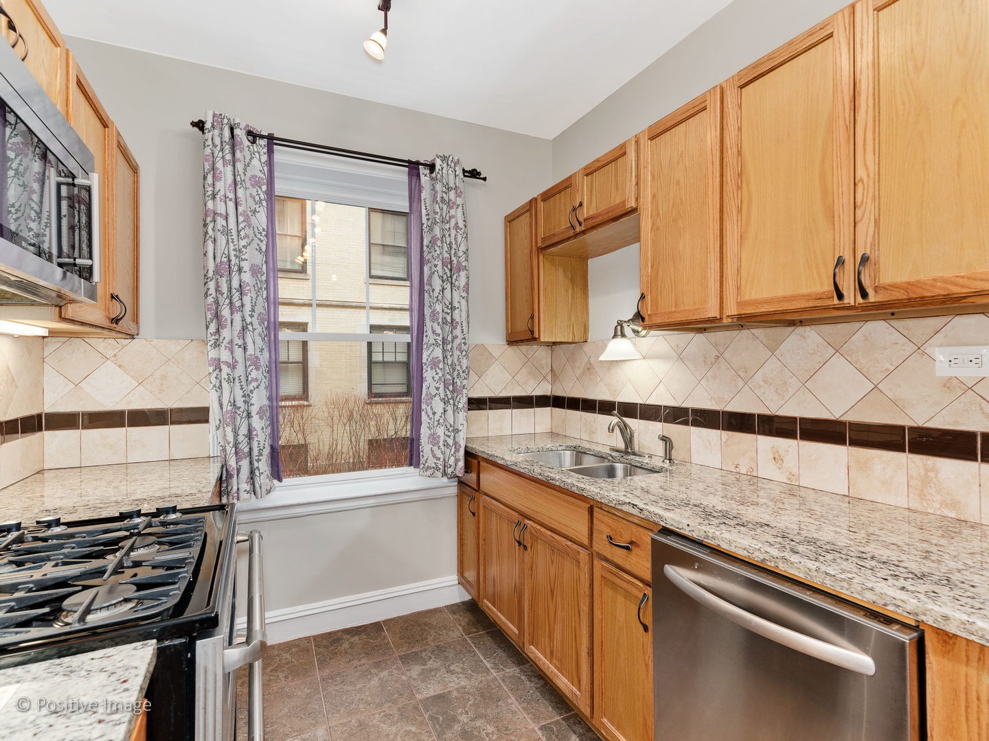 3608 North Pine Grove Avenue, Unit 1M Chicago, IL 60613 - Photo 15 of 24 a kitchen with stainless steel appliances granite countertop a sink stove and cabinets