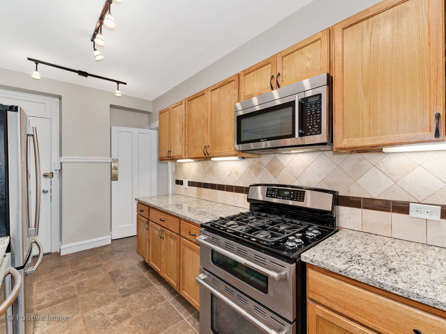 3608 North Pine Grove Avenue, Unit 1M Chicago, IL 60613 - Photo 16 of 24 a kitchen with stainless steel appliances granite countertop a stove and a microwave