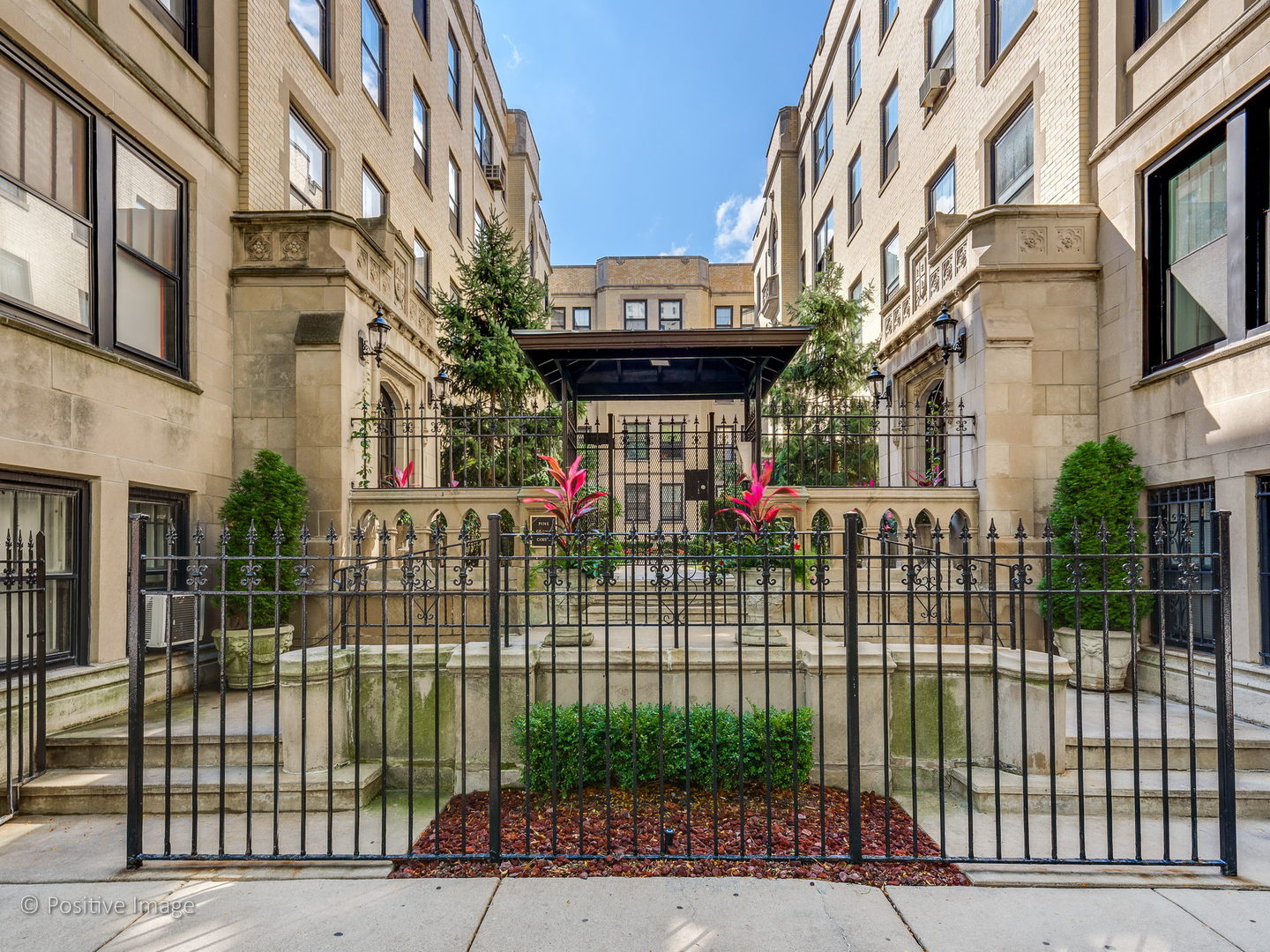 3608 North Pine Grove Avenue, Unit 1M Chicago, IL 60613 - Photo 2 of 24 a view of a brick house with a small yard and plants