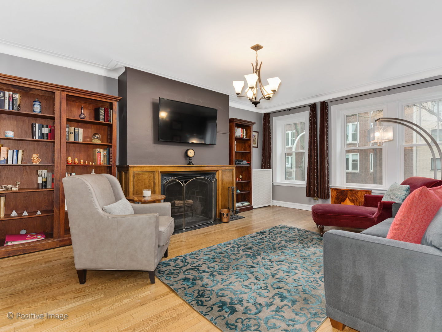 3608 North Pine Grove Avenue, Unit 1M Chicago, IL 60613 - Photo 8 of 24 a living room with furniture a flat screen tv and a fireplace