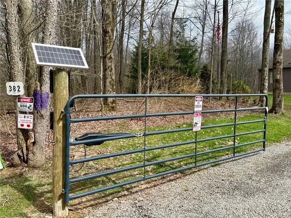 a view of a wooden fence and a sign on the side of the road