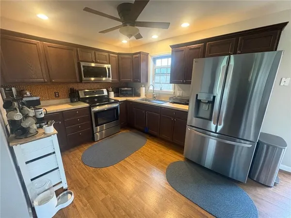 a kitchen with stainless steel appliances granite countertop a refrigerator a stove a sink and a microwave