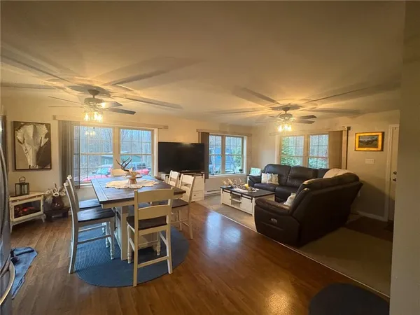 a living room with furniture a wooden floor and a flat screen tv
