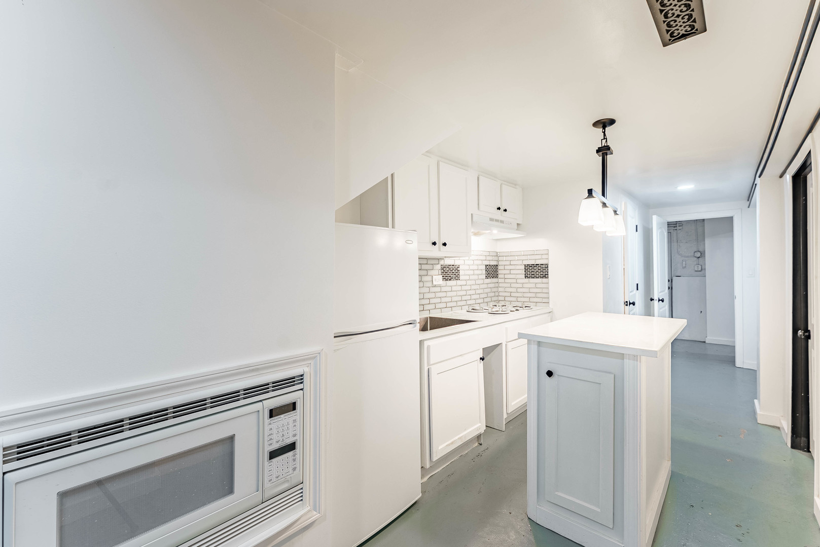 1908 South Sawyer Avenue Chicago, IL 60623 - Photo 21 of 31 a kitchen with kitchen island a white cabinets and white appliances
