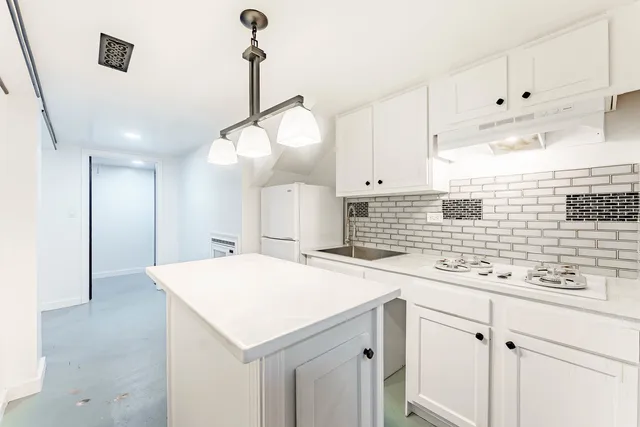 a kitchen with a sink a stove a refrigerator and cabinets