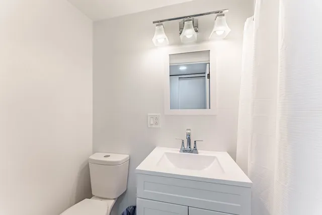 a bathroom with a toilet sink and mirror