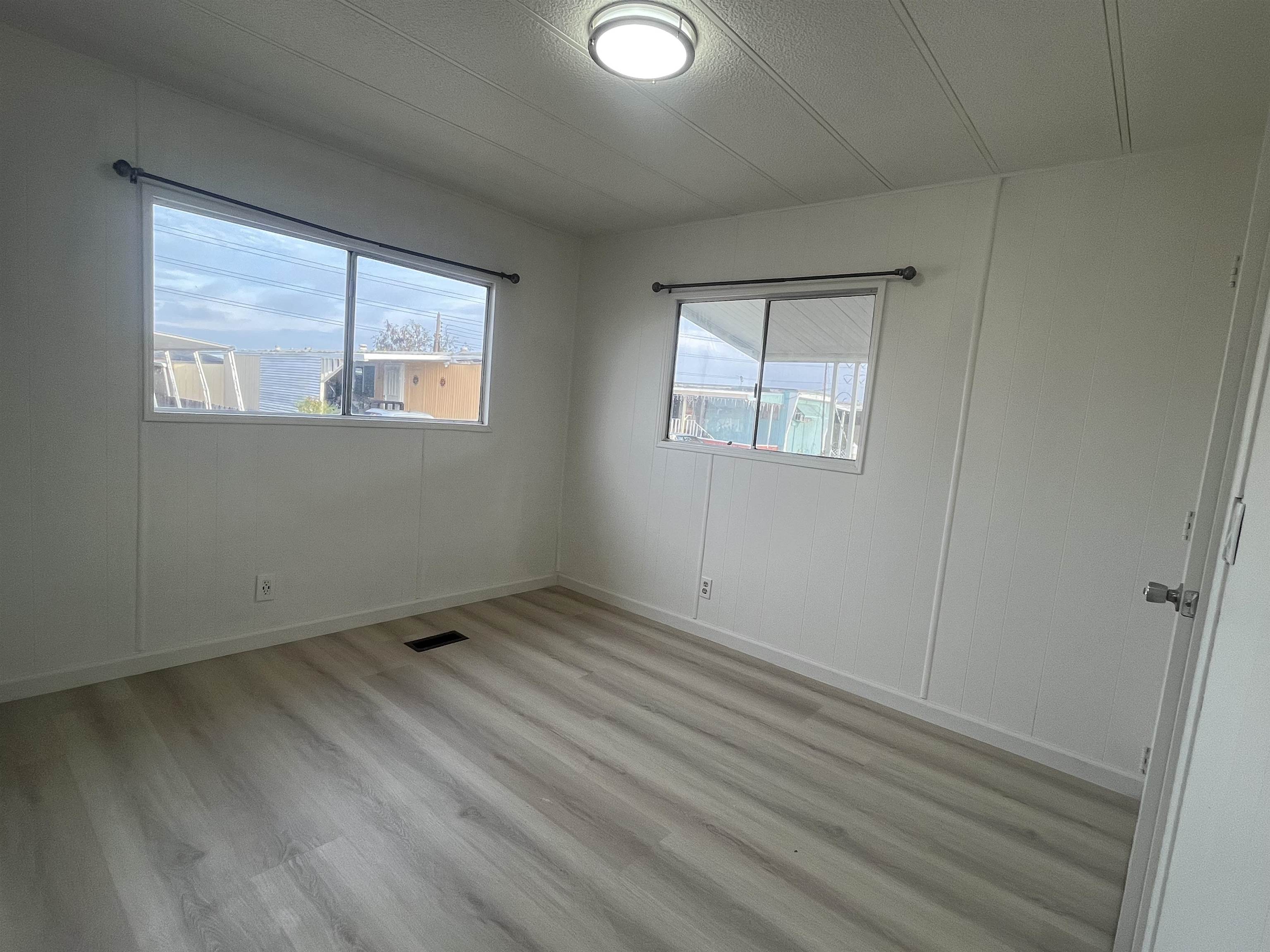 4143 Yosemite Boulevard, Unit C21 Modesto, CA 95357 - Photo 18 of 22 an empty room with wooden floor and windows
