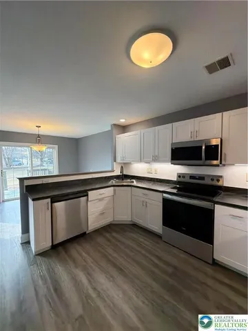a large kitchen with stainless steel appliances granite countertop a stove and a sink