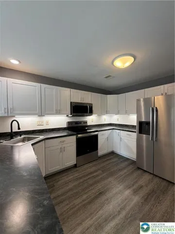 a large kitchen with a center island and stainless steel appliances