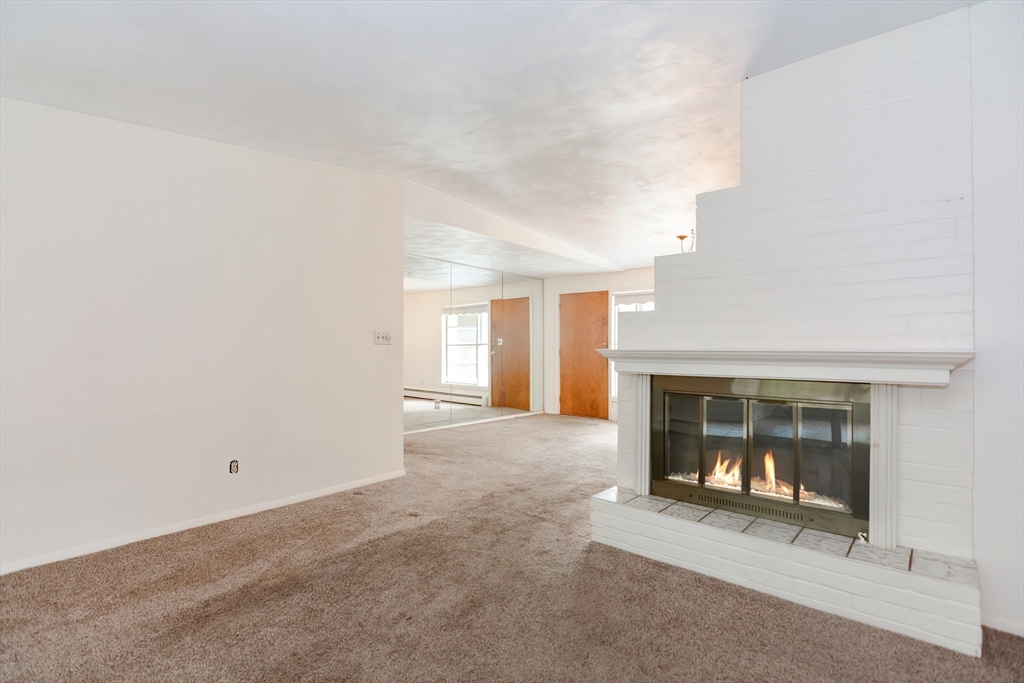 12 Catherine Road Framingham, MA 01701 - Photo 17 of 40 an empty room with a fireplace and cabinet