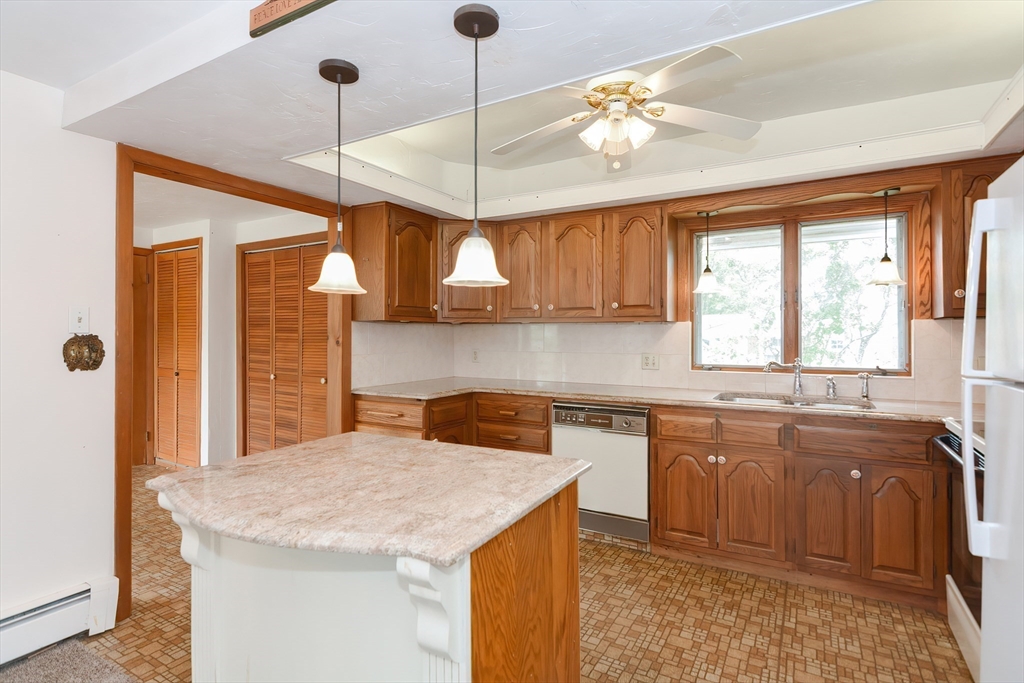 12 Catherine Road Framingham, MA 01701 - Photo 8 of 40 a kitchen with a stove a sink a center island and cabinets