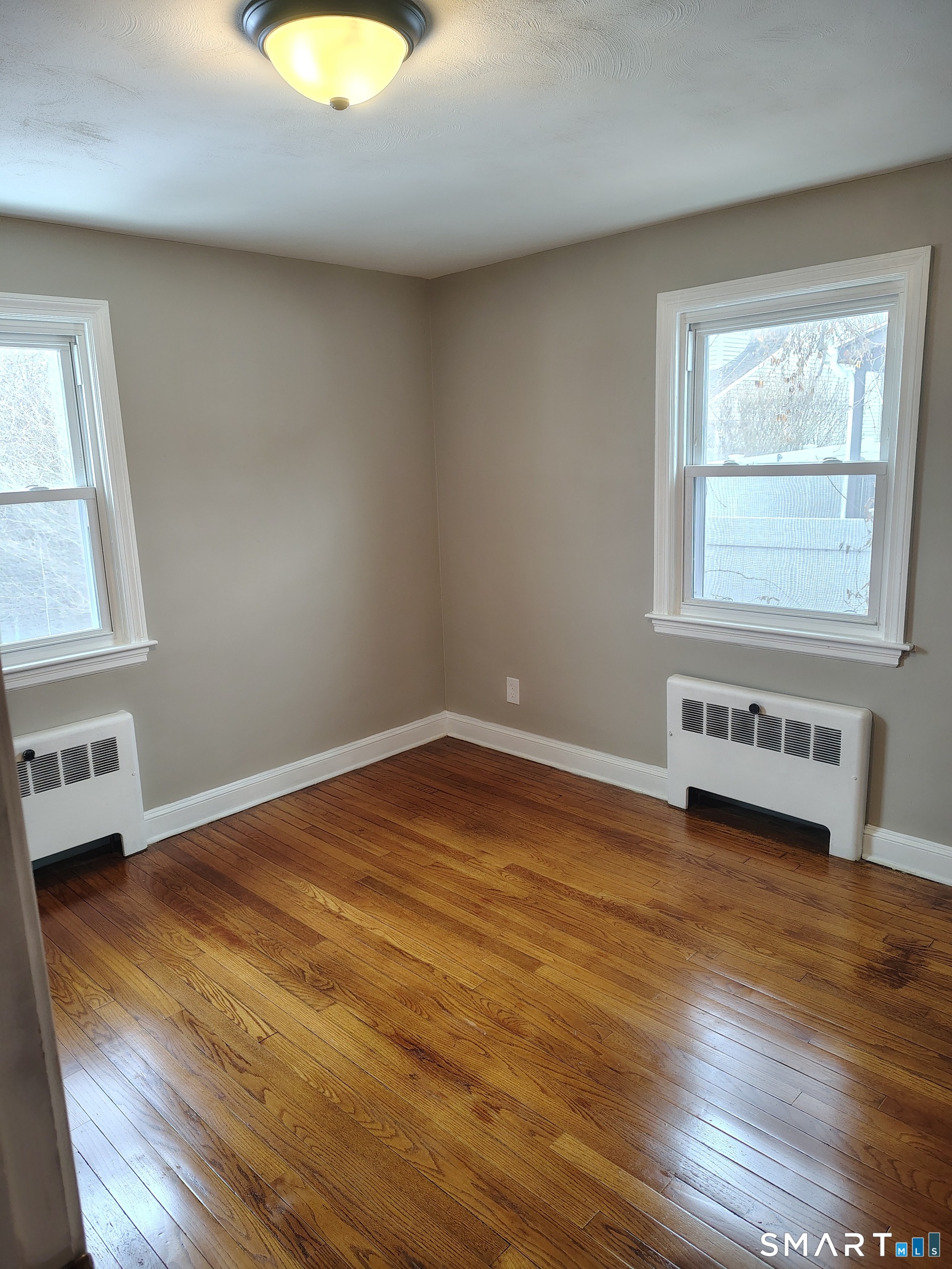 166 George Street Hartford, CT 06114 - Photo 5 of 29 an empty room with wooden floor and windows