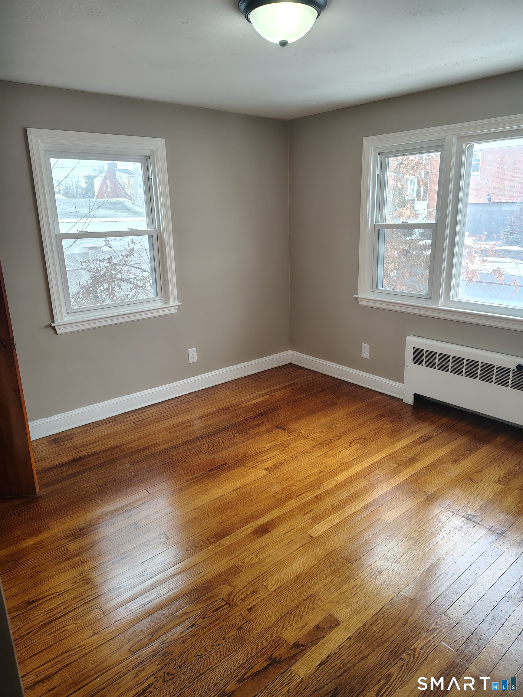 166 George Street Hartford, CT 06114 - Photo 6 of 29 a view of an empty room with wooden floor and a window