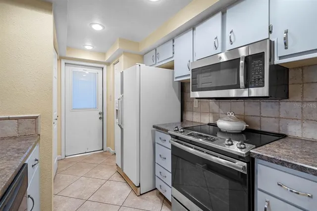 a kitchen with stainless steel appliances granite countertop a stove microwave and refrigerator