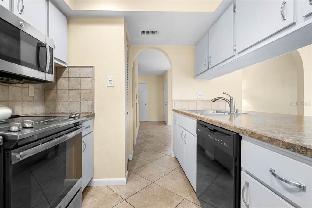 903 Buck Court Brandon, FL 33511 - Photo 9 of 24 a kitchen with stainless steel appliances granite countertop a sink and a stove
