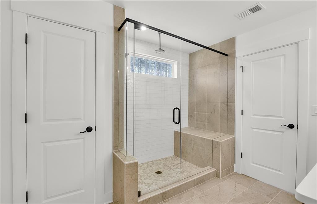 5375 Julep Court Cumming, GA 30028 - Photo 17 of 22 a bathroom with a glass shower door