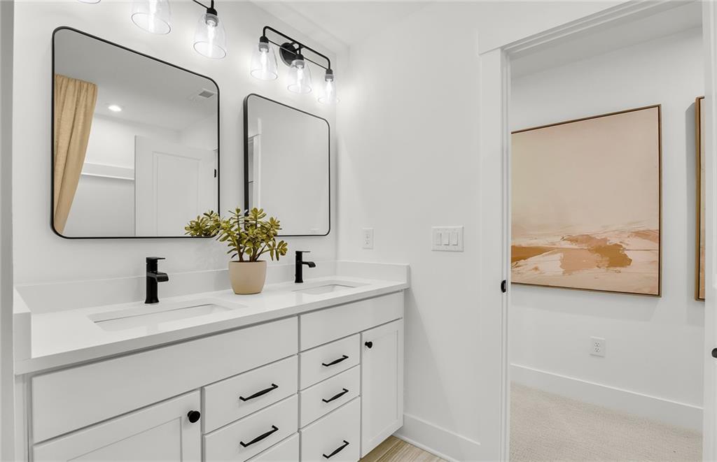 5375 Julep Court Cumming, GA 30028 - Photo 21 of 22 a bathroom with a double vanity sink and a mirror
