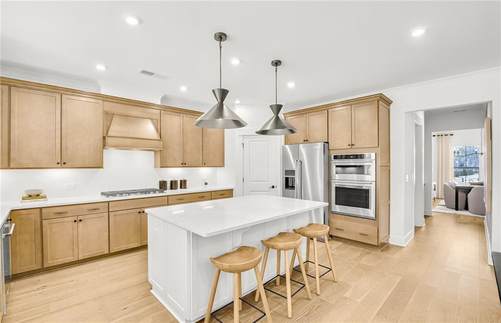 5375 Julep Court Cumming, GA 30028 - Photo 5 of 22 a kitchen with stainless steel appliances kitchen island granite countertop a stove a sink and a refrigerator