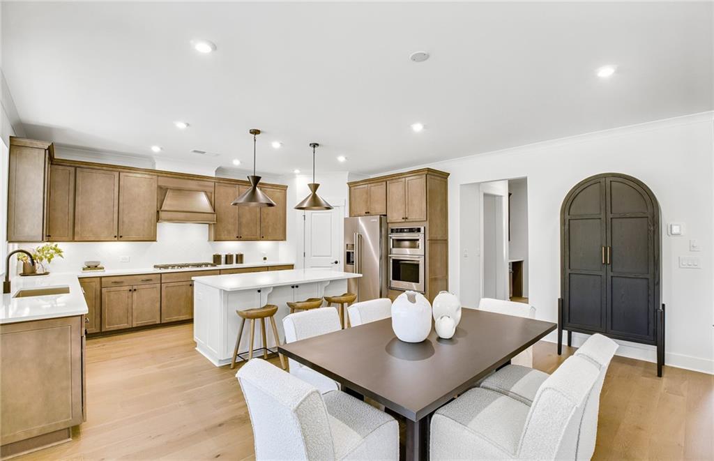 5375 Julep Court Cumming, GA 30028 - Photo 8 of 22 a open kitchen with stainless steel appliances kitchen island granite countertop a table chairs and a refrigerator