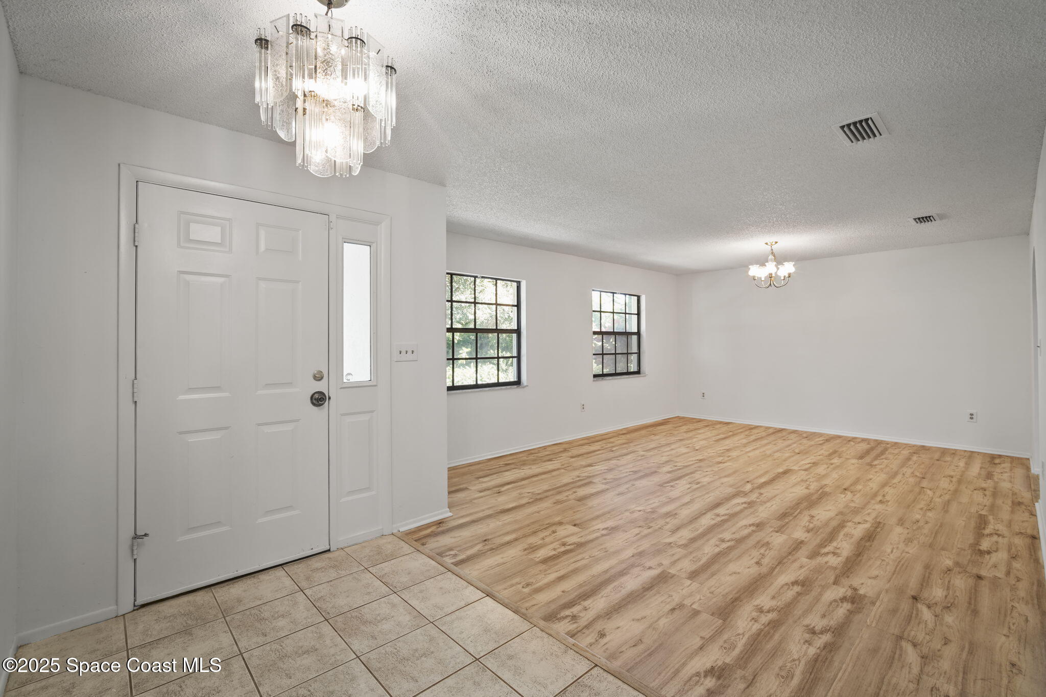 3125 Lionel Road Mims, FL 32754 - Photo 4 of 31 a view of a livingroom with a chandelier fan and windows