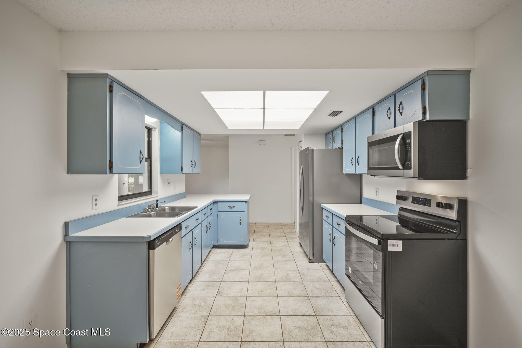 3125 Lionel Road Mims, FL 32754 - Photo 10 of 31 a kitchen with stainless steel appliances granite countertop a sink stove top oven and microwave