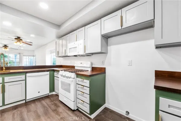 a kitchen with stainless steel appliances white cabinets and a stove top oven