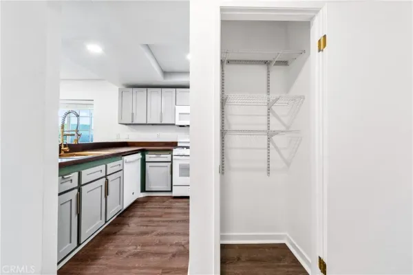 a kitchen with granite countertop white cabinets and white appliances