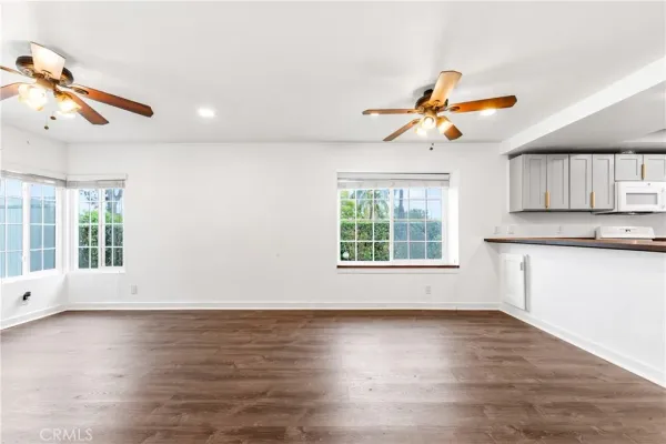 a view of a kitchen with wooden floor and a ceiling fan