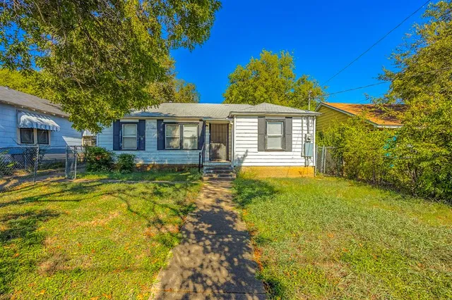 a front view of house with yard and trees around