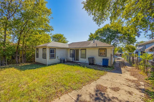 a view of a house with a large tree and a yard