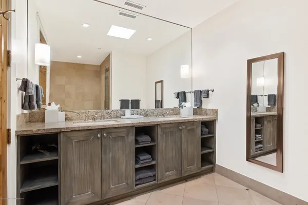 a bathroom with a double vanity sink and a mirror