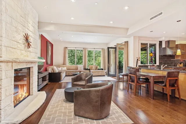 a living room with fireplace furniture and a large window