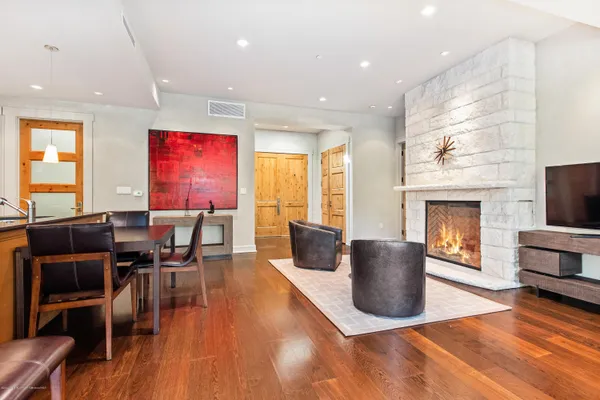 a dining room with furniture a fireplace and wooden floor