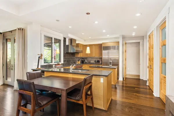a kitchen with a table chairs and flat screen tv