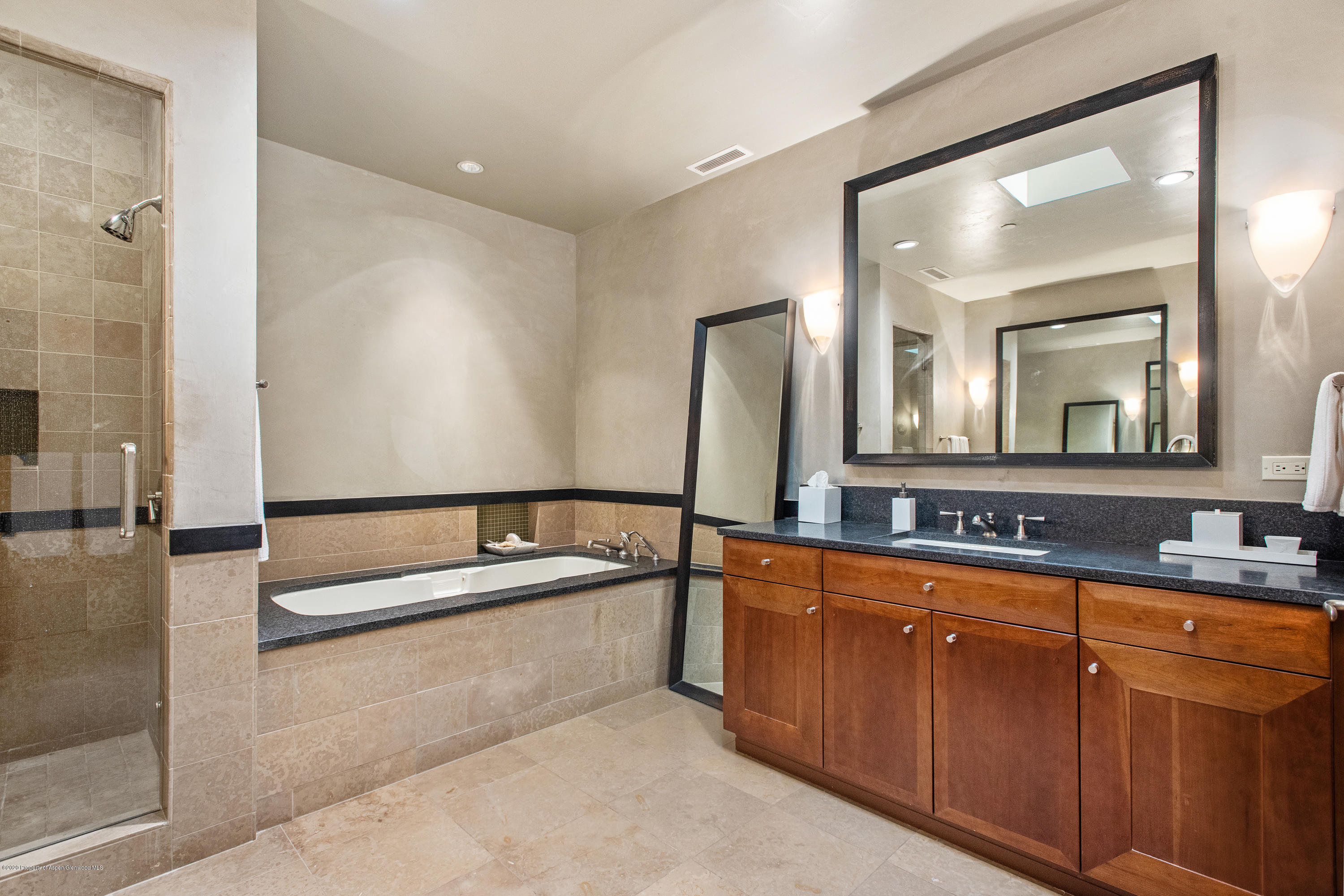 501 Rio Grande Place, Unit 205 Aspen, CO 81611 - Photo 9 of 17 a bathroom with a bathtub a double vanity sink and mirror