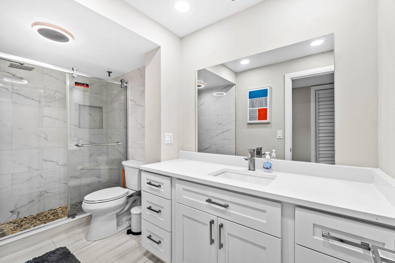 899 Jeffery Street, Unit 2120 Boca Raton, FL 33487 - Photo 16 of 38 a bathroom with a sink toilet vanity and shower