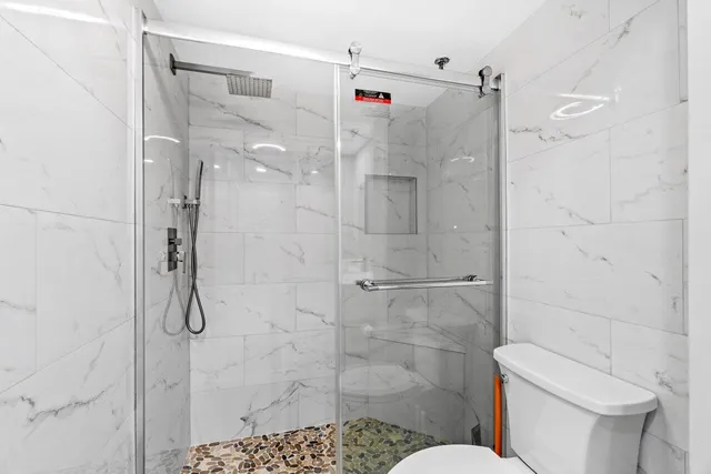 a bathroom with a shower toilet and sink