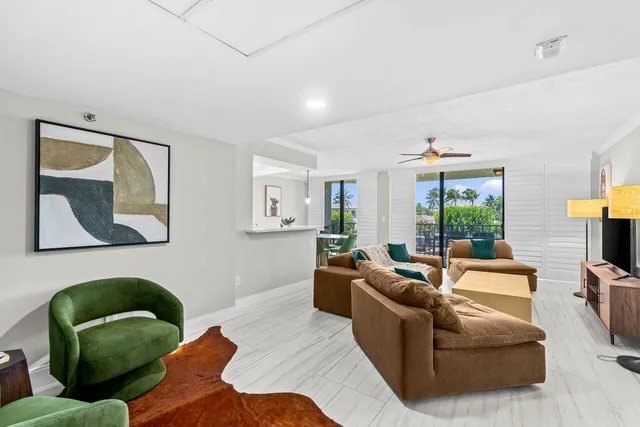 a living room with furniture ceiling fan and a window