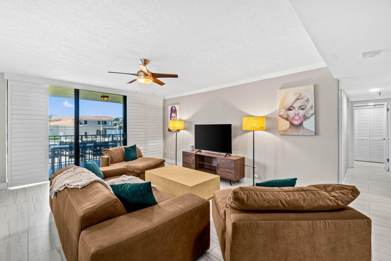 899 Jeffery Street, Unit 2120 Boca Raton, FL 33487 - Photo 5 of 38 a living room with furniture ceiling fan and a flat screen tv