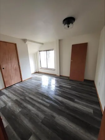 wooden floor in an empty room with a window