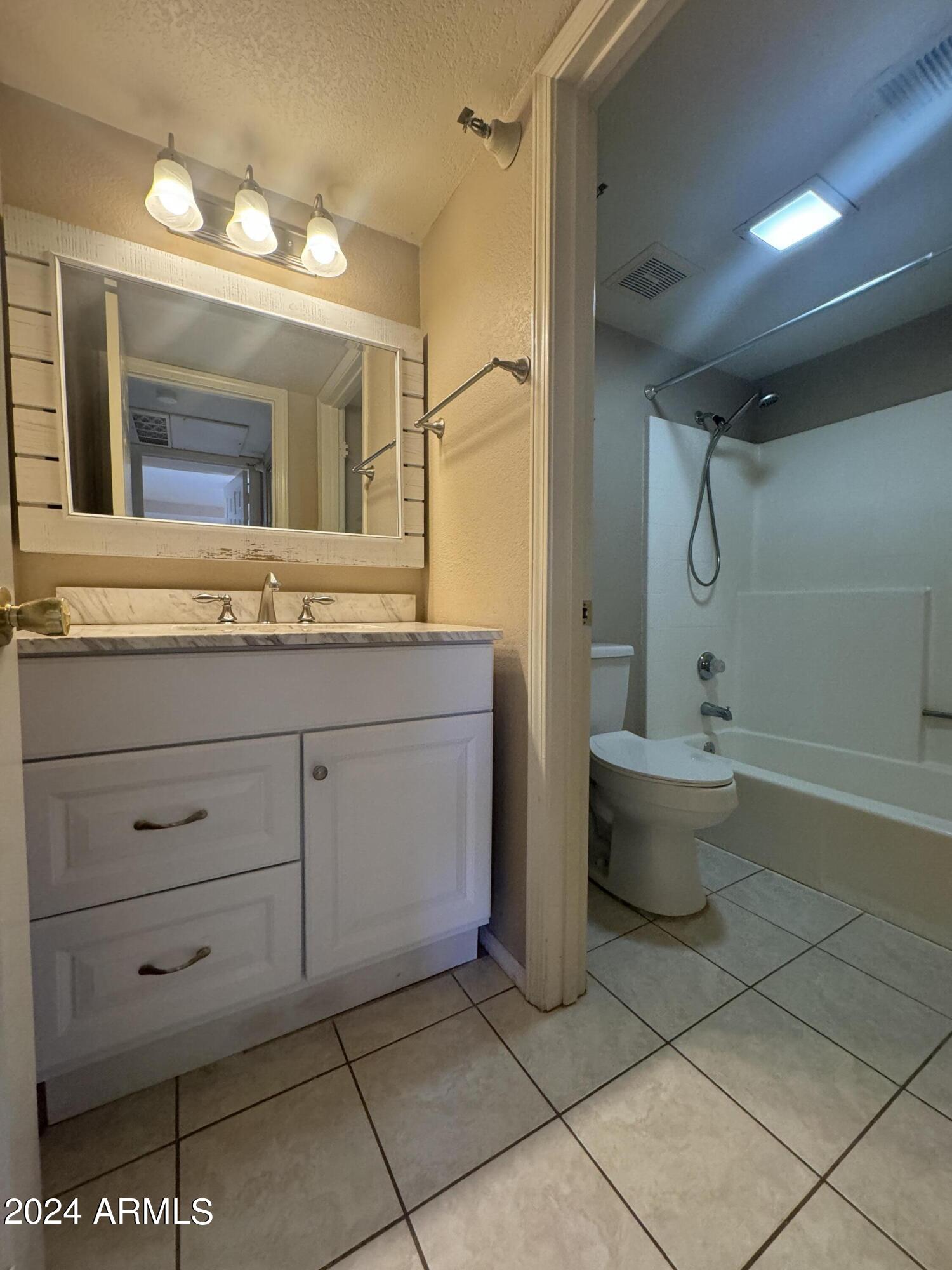 8020 East Thomas Road, Unit 226 Scottsdale, AZ 85251 - Photo 9 of 16 a bathroom with a granite countertop sink a toilet and bathtub
