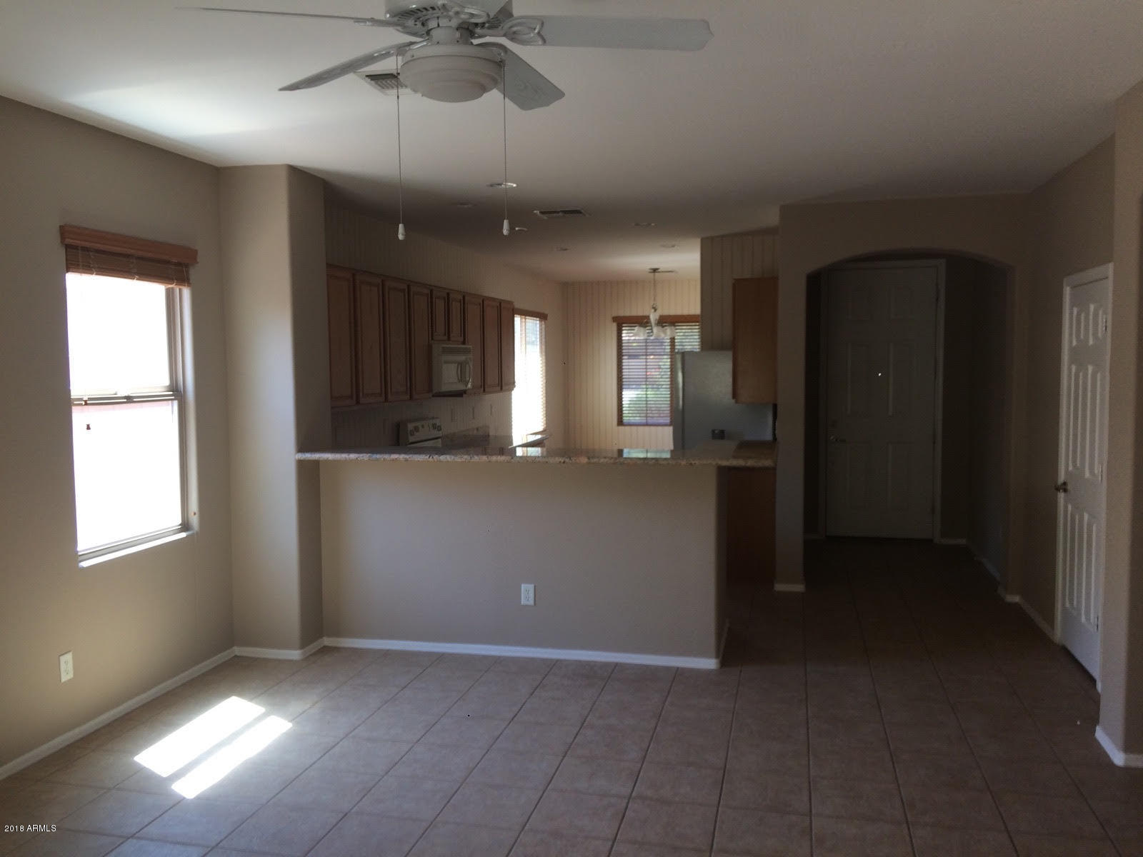 4147 South Bandit Court Gilbert, AZ 85297 - Photo 2 of 4 wooden floor in an empty room with a kitchen